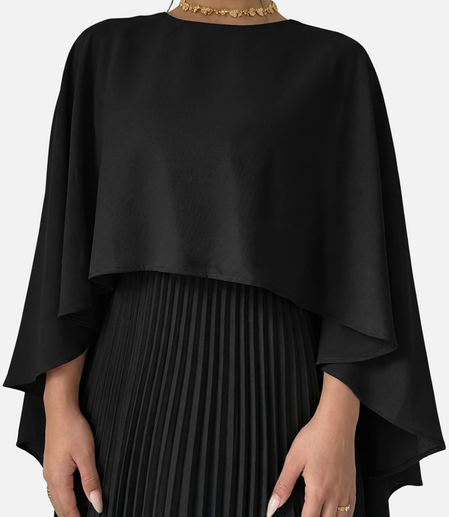 Close-up of black cape overlay maxi dress with pleated skirt and draped formal top
