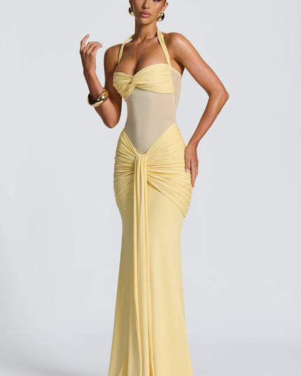 Side angle of yellow halter maxi dress showing ruched waist and hip gathering