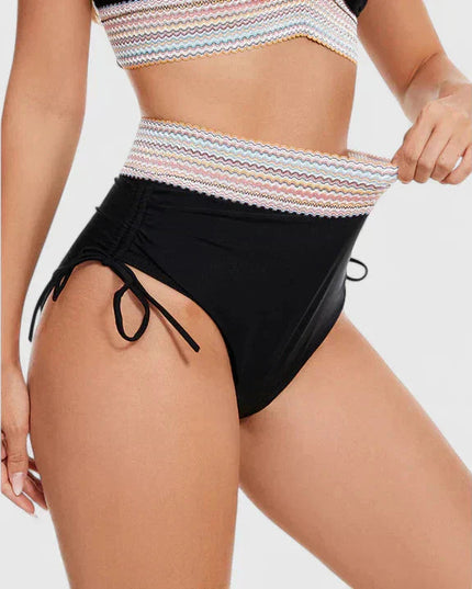 Close-up of black bikini bottoms with multicolor striped waistband and ties