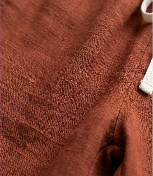 Close-up of rust linen fabric texture and weave detail