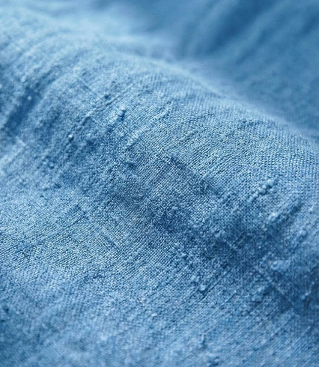 Close-up of light blue linen fabric texture showing weave detail