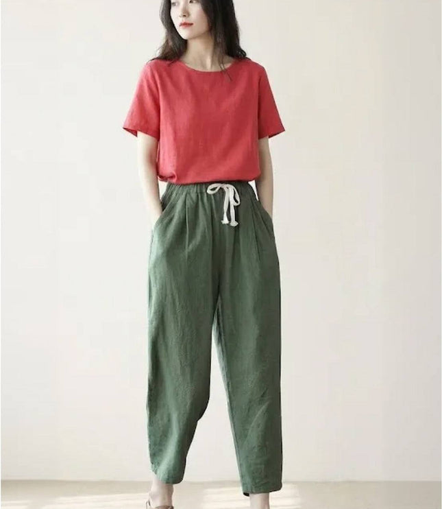 Sage green linen pants with cream tie waist in neutral room setting