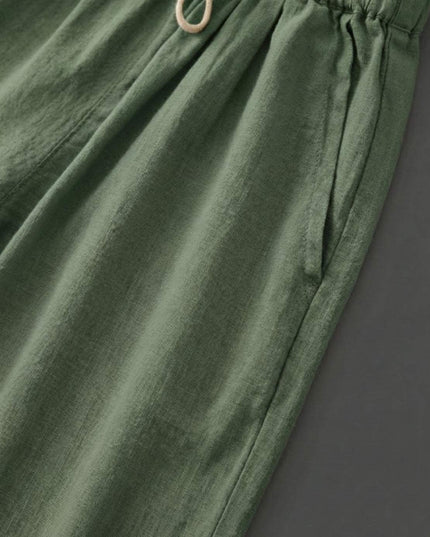Close-up of sage green linen fabric with cream drawstring detail