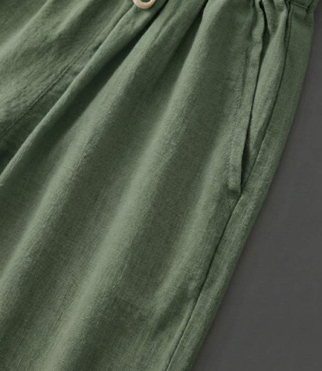 Close-up of sage green linen fabric with cream drawstring detail