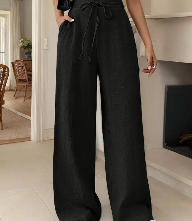 Black women's high waisted linen pants with wide legs, adjustable drawstring, and loose fit