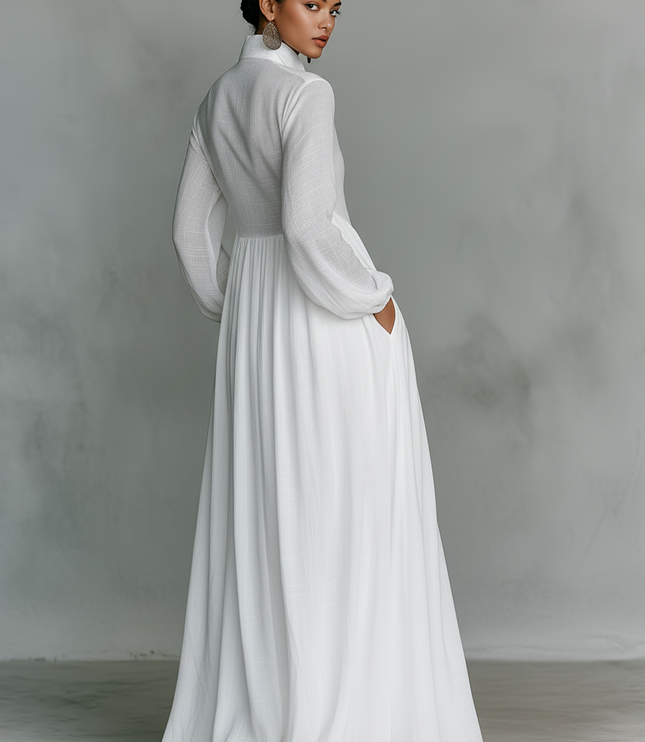 Back view of white maxi dress with long sleeves and flowing pleated skirt