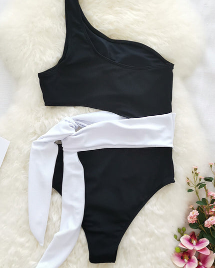 Black one shoulder one piece swimsuit with pink leopard print wrap tie on woven mat