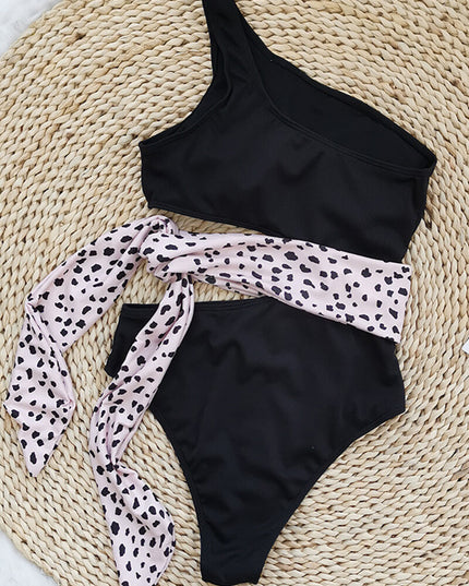 Blue one shoulder one piece swimsuit with pink waist tie and side cutout flat lay