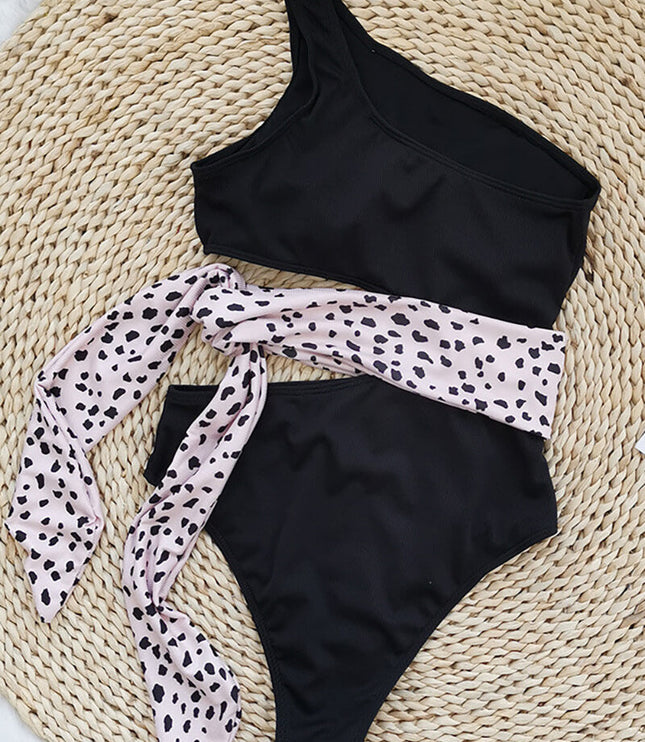 Blue one shoulder one piece swimsuit with pink waist tie and side cutout flat lay