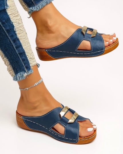 Navy blue platform slides with double gold buckles, tan sole, and white stitching detail