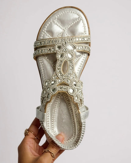 Cream embellished flat sandal with rhinestone flower design, sole view
