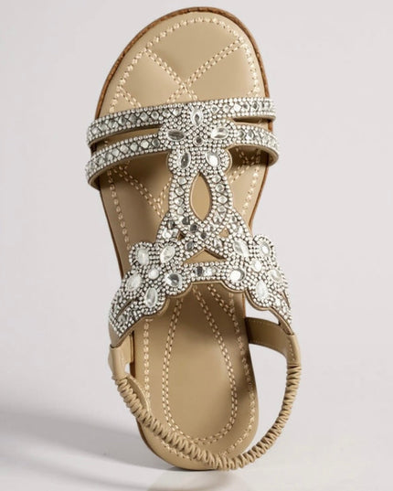 Beige flat sandal with crystal-studded straps and ornate flower design