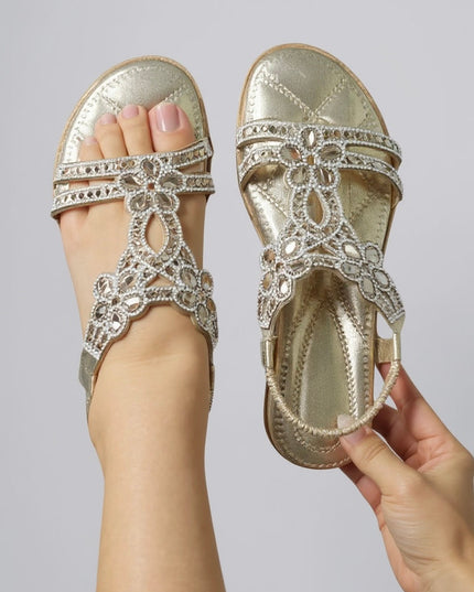 Gold metallic flat sandal with rhinestone flower embellishments, sole view