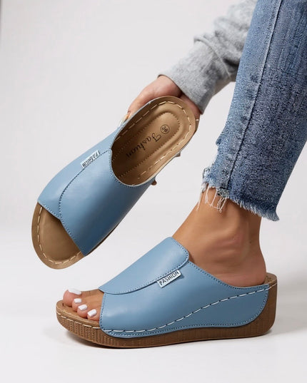 Light blue platform slides with tan contoured footbed and white stitching detail