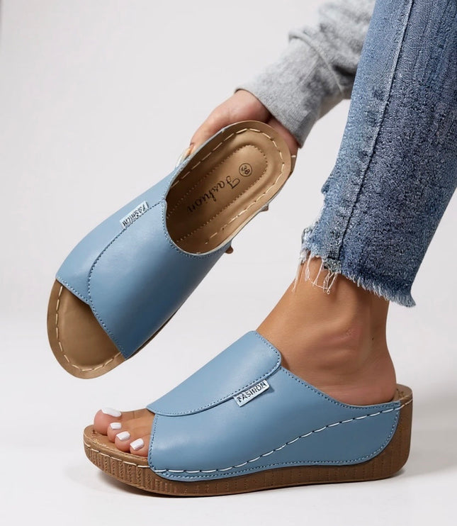 Light blue platform slides with tan contoured footbed and white stitching detail