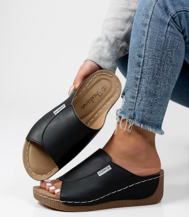 Black platform mule showing contoured footbed detail and stitching