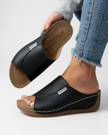 Black leather platform slide with contoured footbed and tan sole