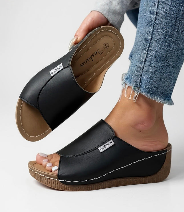 Black leather platform slide with contoured footbed and tan sole
