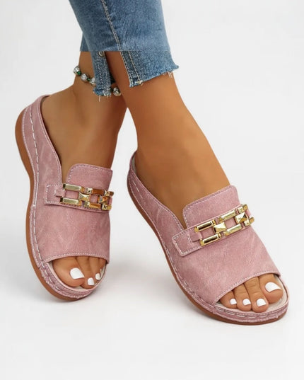 Pink cushioned mule sandal with gold chain embellishment worn with jeans