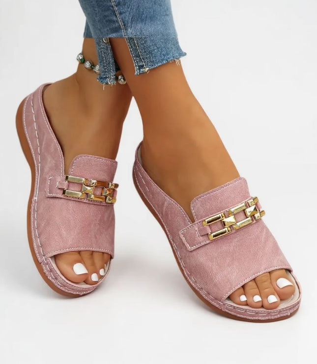 Pink cushioned mule sandal with gold chain embellishment worn with jeans