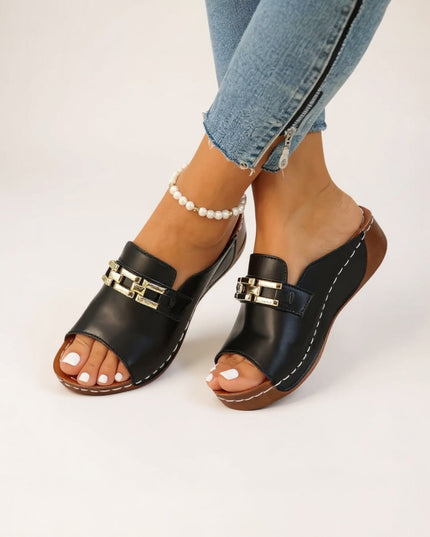 Black leather platform mule with gold chain detail and white stitching