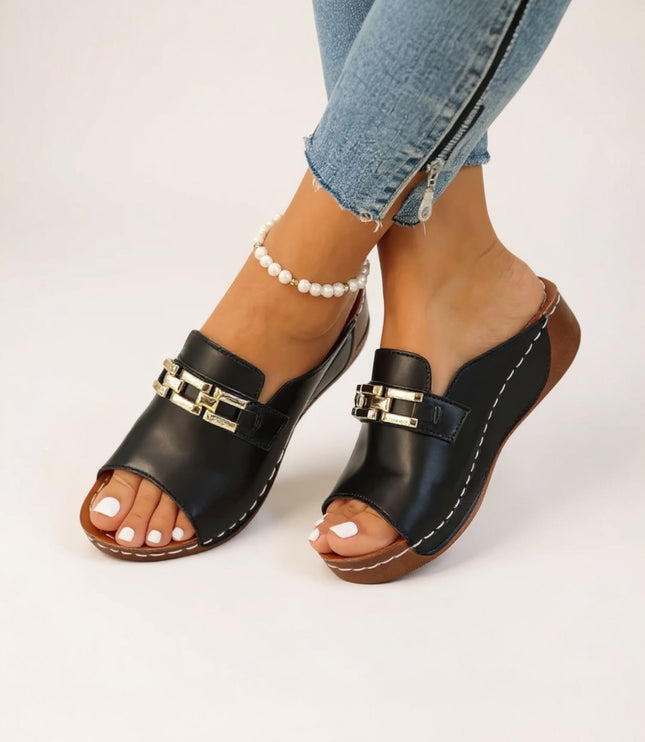 Black leather platform mule with gold chain detail and white stitching