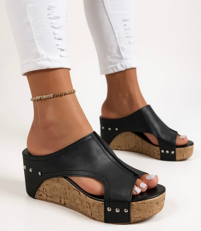Close-up front view of black studded wedge sandal with cork platform sole