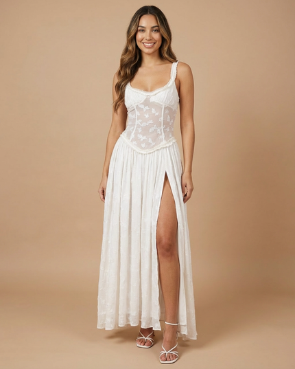 Back angle of light green maxi dress with sheer floral paneling and side slit visible