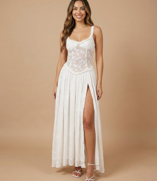 Back angle of light green maxi dress with sheer floral paneling and side slit visible