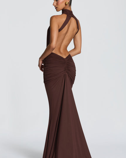 Rear three-quarter view of brown halter maxi dress with open back and ruched skirt