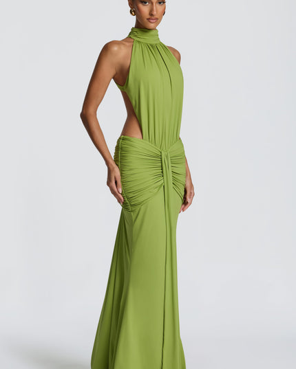 Three-quarter view of green ruched maxi dress with halter neckline and side cutouts