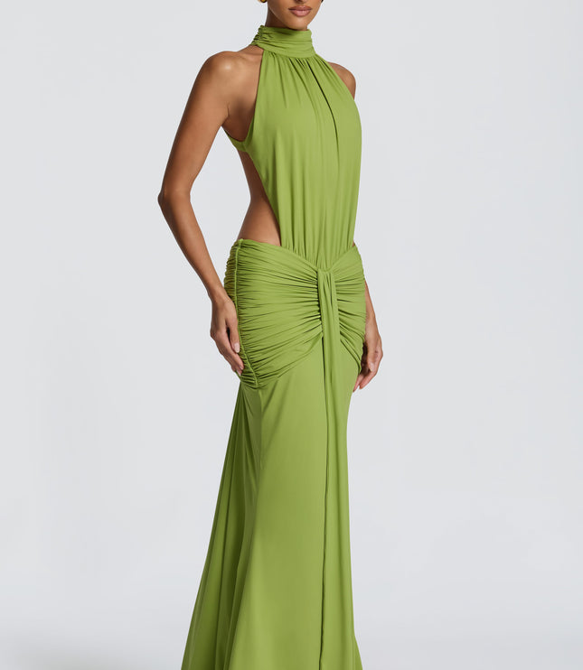 Three-quarter view of green ruched maxi dress with halter neckline and side cutouts