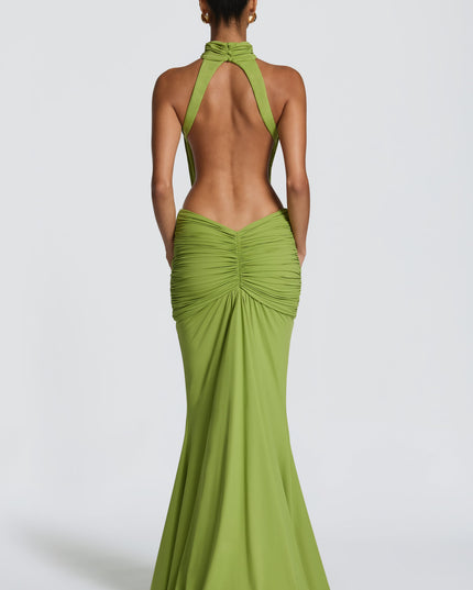 Back view of green maxi dress with open back, halter straps, and ruched skirt detail