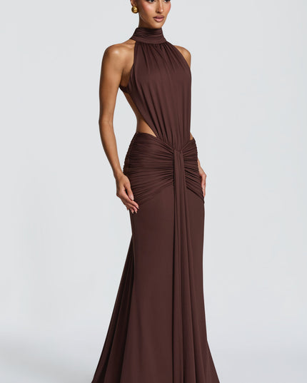 Three-quarter view of brown ruched maxi dress with high halter neckline and open sides