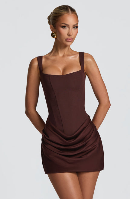 Front view of a women's party mini dress in dark brown with a square neck and structured bodice, featuring subtle draping on the skirt.