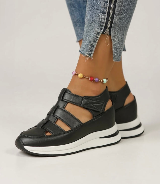 Black leather platform sandals with adjustable straps and white cushioned sole