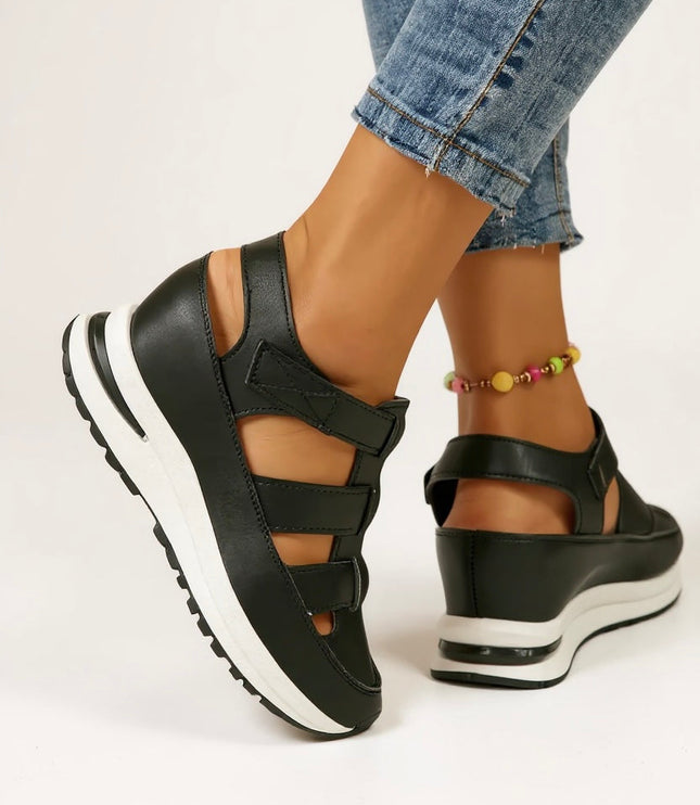Black cushioned platform sandals with adjustable buckle straps, back angle