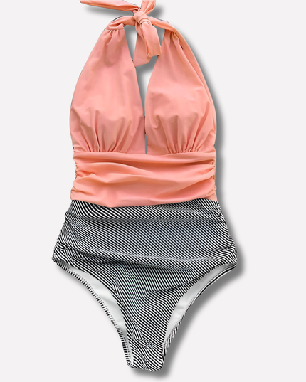 Coral halter swimsuit with black striped ruched high-waisted bottom, flat lay