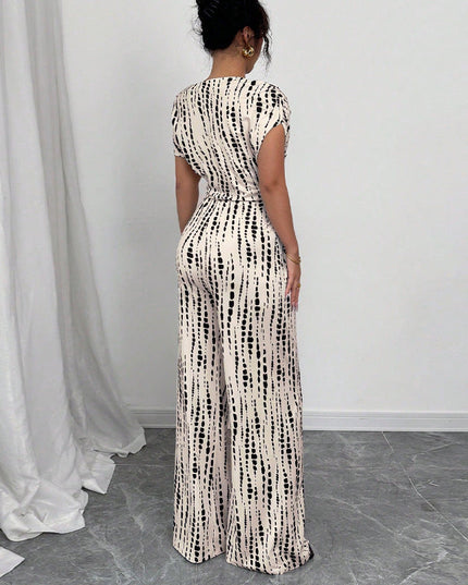 Back view of white wide-leg jumpsuit with black striped print and tie-waist detail