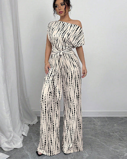 White jumpsuit with black dash print, off-shoulder neckline, short sleeves, wide-leg silhouette