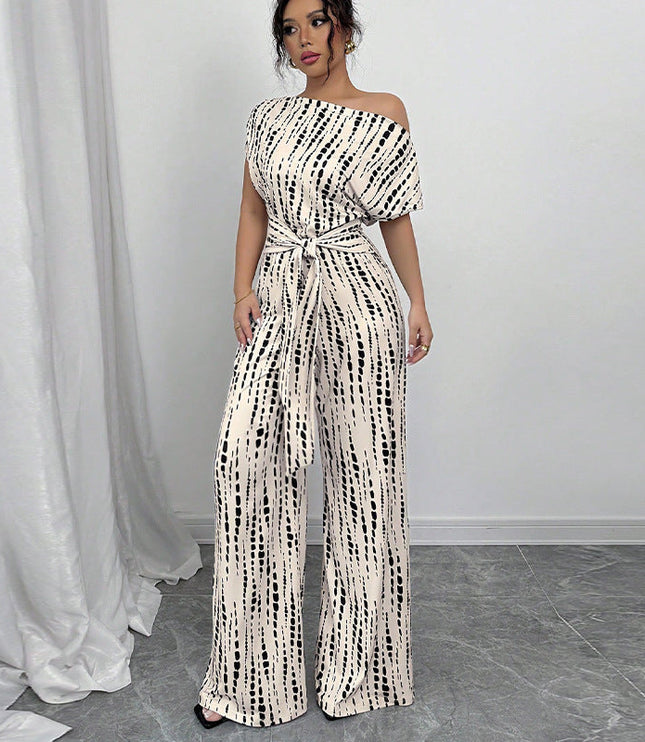 White jumpsuit with black dash print, off-shoulder neckline, short sleeves, wide-leg silhouette