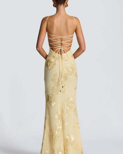 Back view of cream dress with crisscross lace-up straps and gold floral embroidery