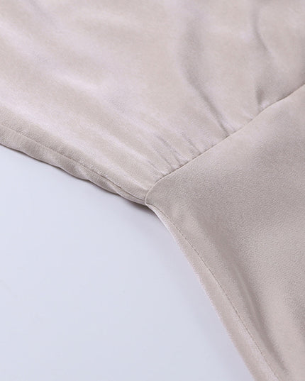 Beige draped maxi dress fabric detail showing soft folds and texture