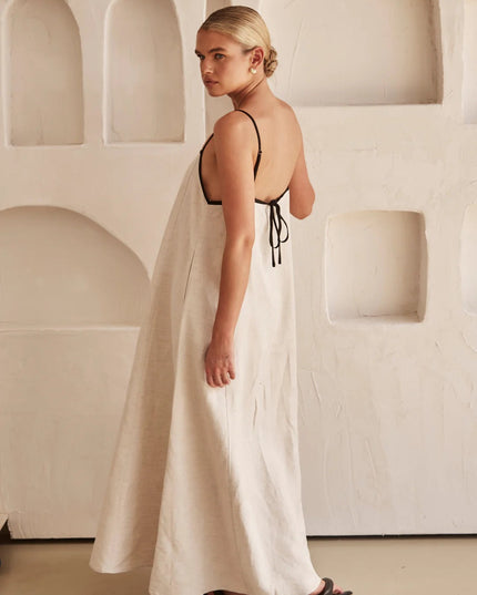 Back view of cream maxi dress showing open back with black tie straps
