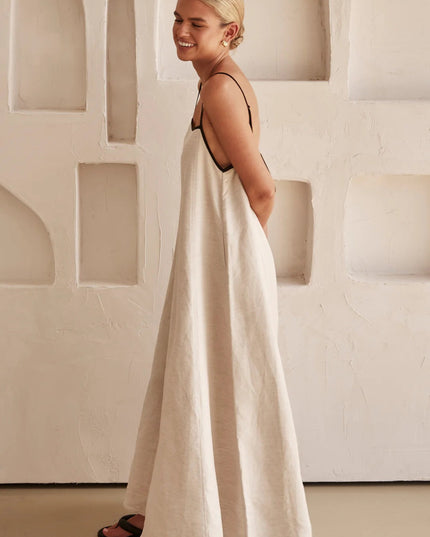 Side view of cream maxi dress showing relaxed drape and open back detail