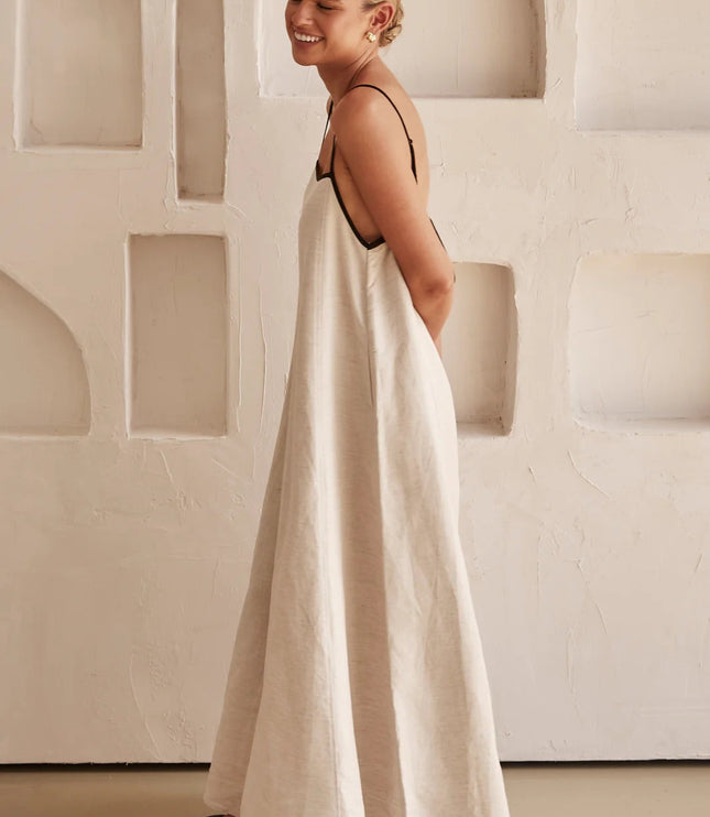 Side view of cream maxi dress showing relaxed drape and open back detail