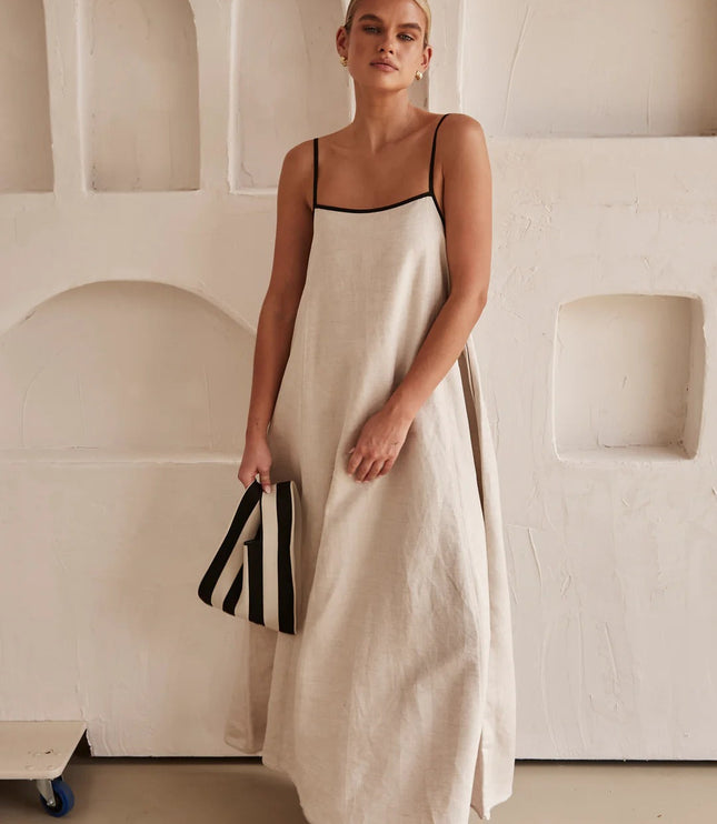 Cream spaghetti strap maxi dress with black trim and flowing silhouette