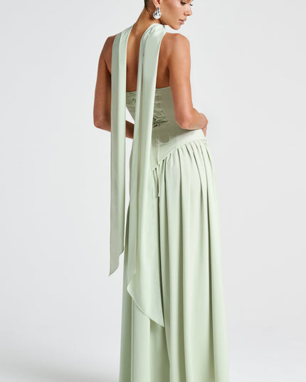 Back view of pale green strapless asymmetrical maxi dress with flowing fabric