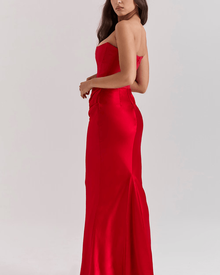Side view of a women's red strapless sweetheart corset maxi dress, highlighting the back silhouette and floor-length design.