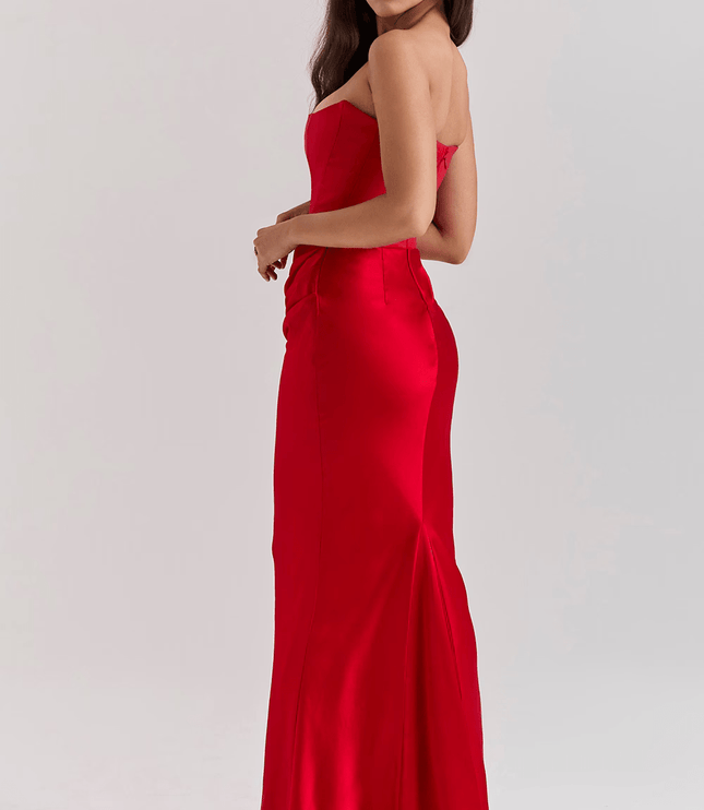 Side view of a women's red strapless sweetheart corset maxi dress, highlighting the back silhouette and floor-length design.